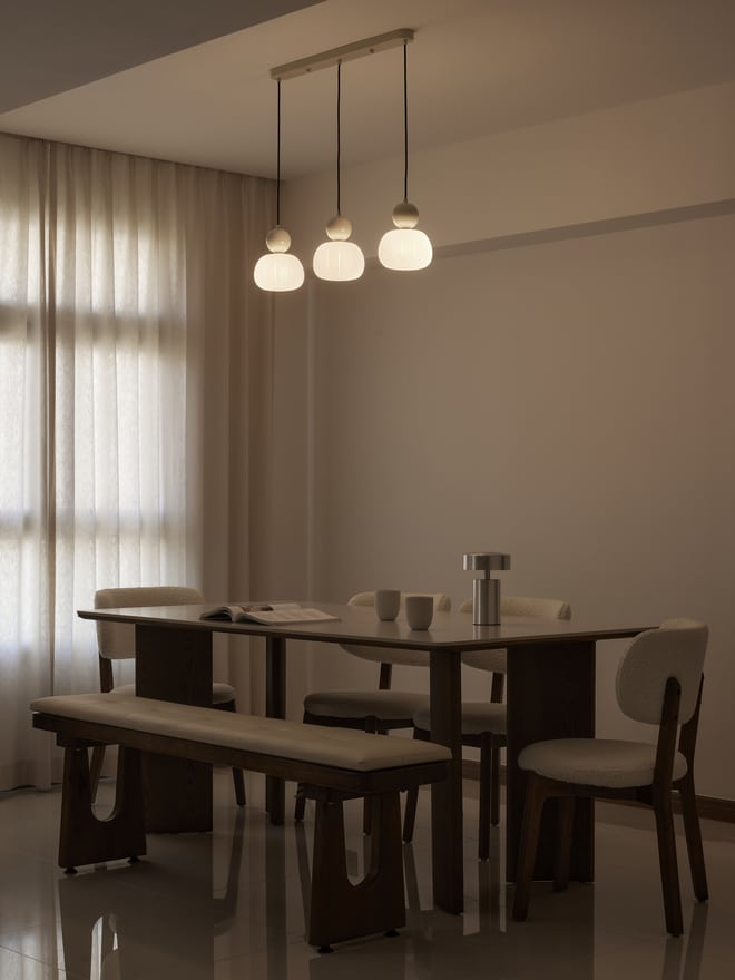 HDB dining area design with three-bulb lighting, creating warm ambience and functional open space layout
