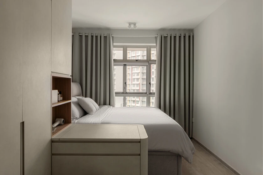 Cozy small bedroom interior featuring neat window curtains, built-in cabinets, and a clever, space-saving design
