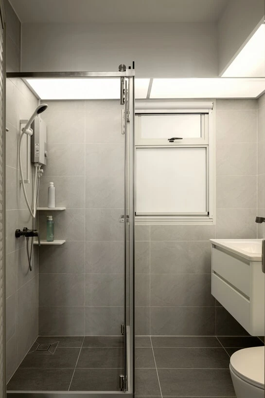 Modern toilet interior featuring a sleek toilet bowl and a walk-in shower separated by a clear glass partition.