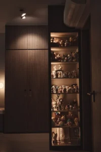 Modern luxury cabinets and open shelving styled with decorative figurines, creating a sophisticated home interior.